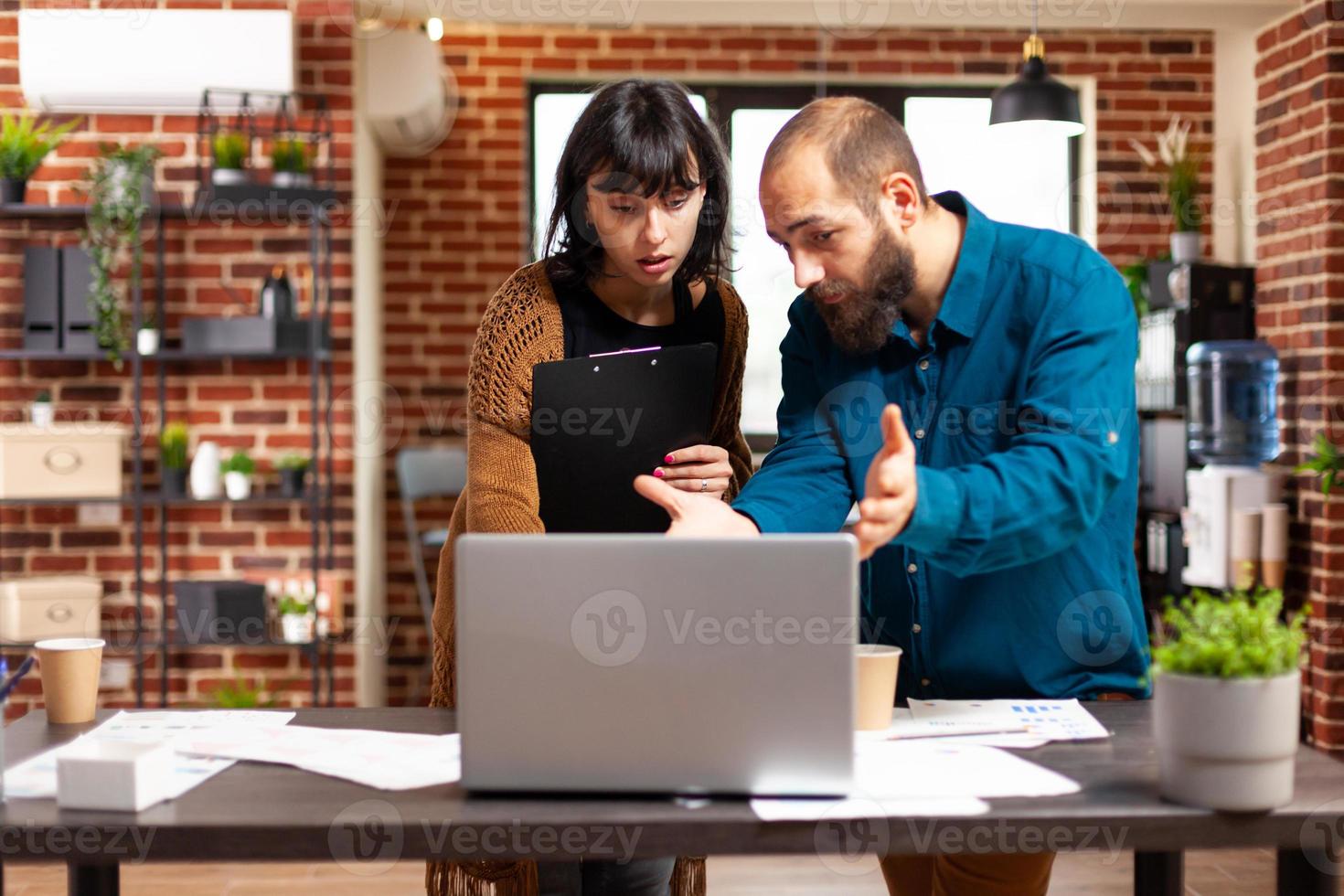 Businessman showing management graphs to executive manager woman photo