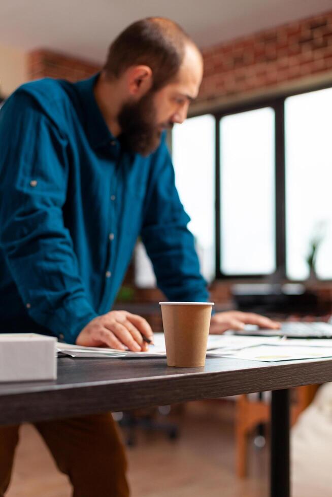 Businessman analyzing company statistics on laptop computer checking marketing strategy photo