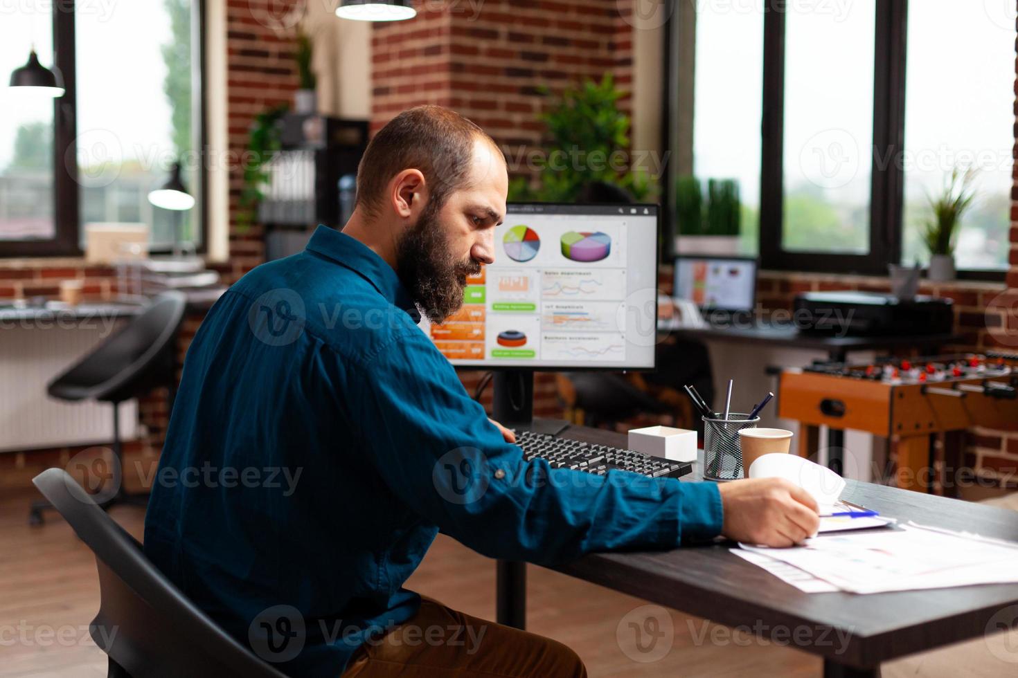 Entrepreneur man sitting at desk table analyzing business documents working at marketing presentation photo