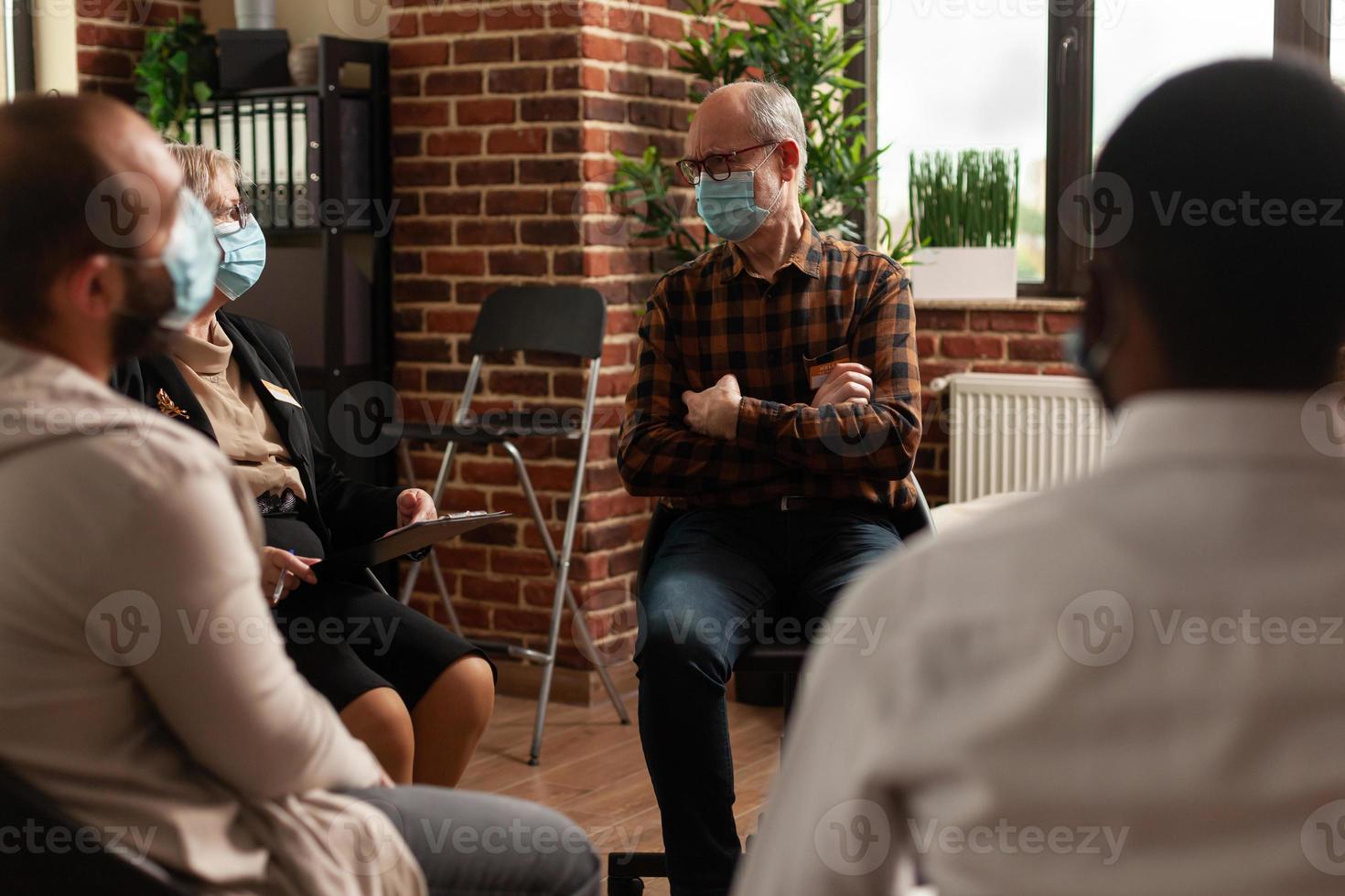 hombre mayor, con, mascarilla, hablar, gente, en círculo, en, un, reunión foto