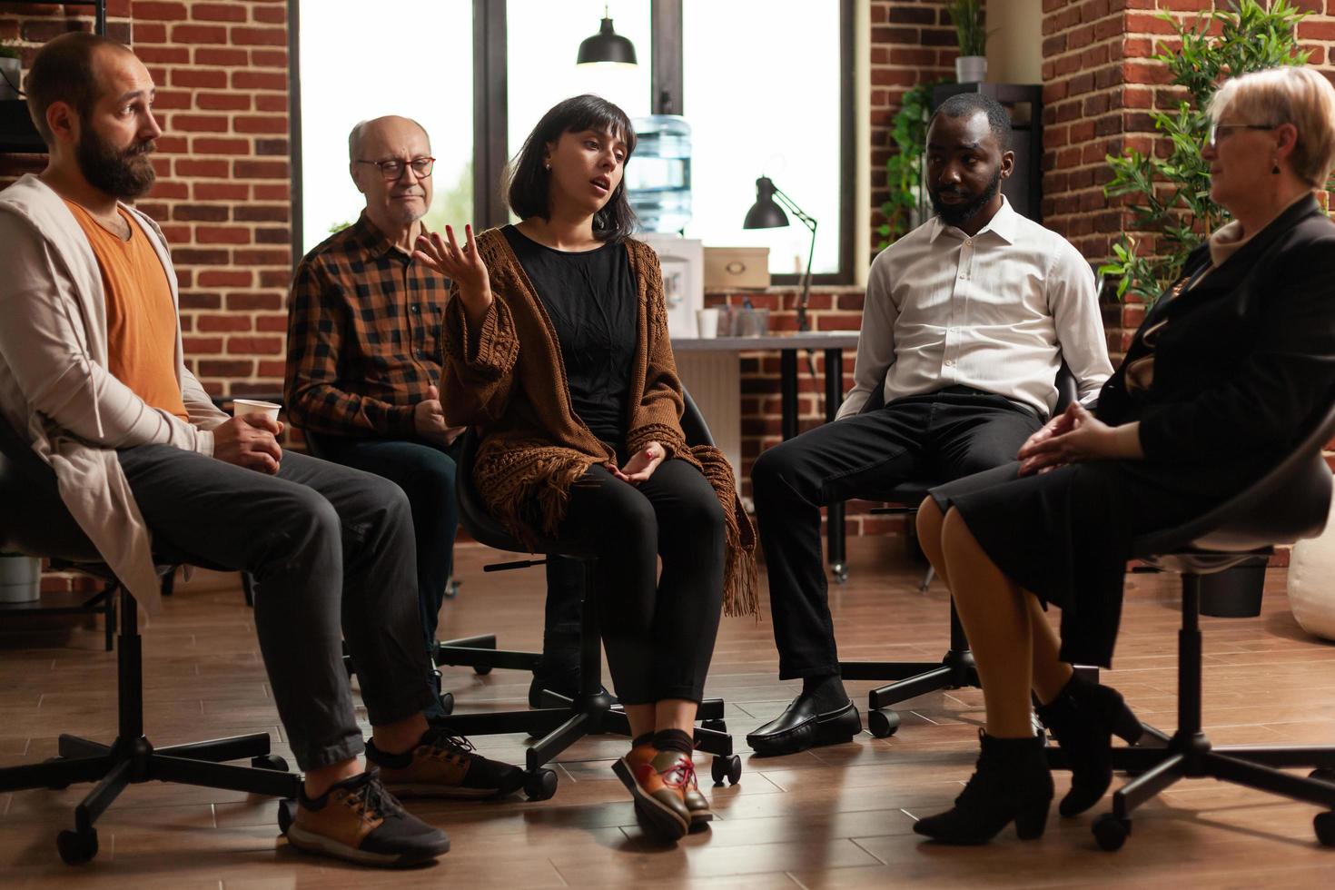 Woman talking to people with addiction at aa group meeting photo