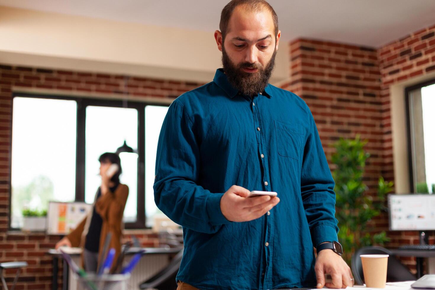 Businessman holding modern smartphone waiting for imporant call looking at watch time photo