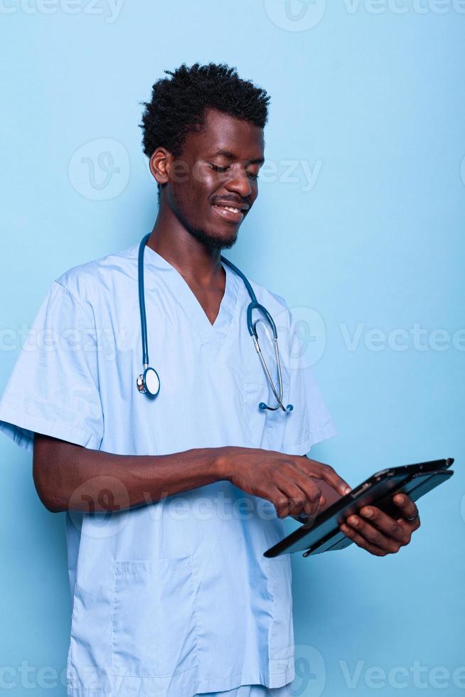 Medical assistant looking at digital tablet in hand photo