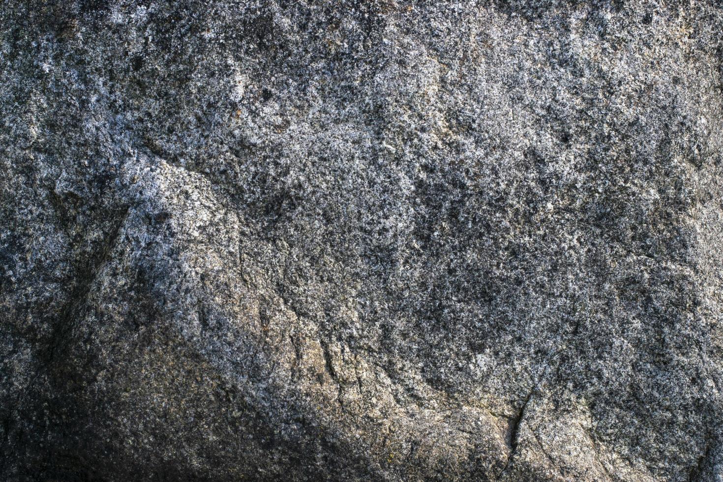 Raw gray granite rock texture background. Fragment of natural stone wall photo