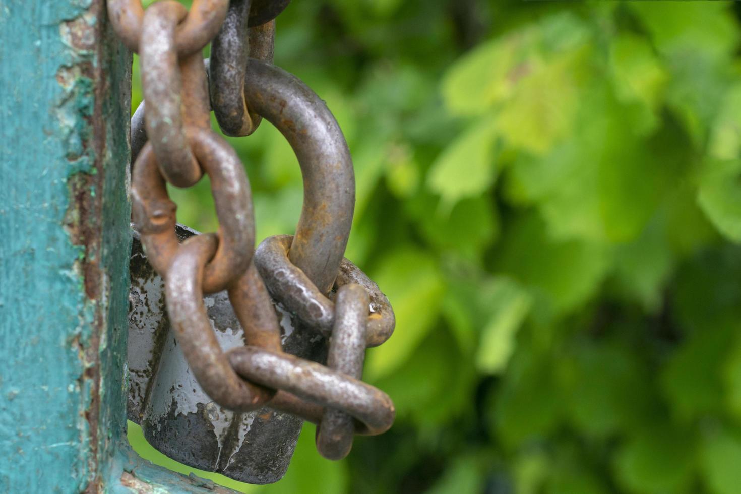 Old gray padlock on a chain. Vintage lock close up. photo