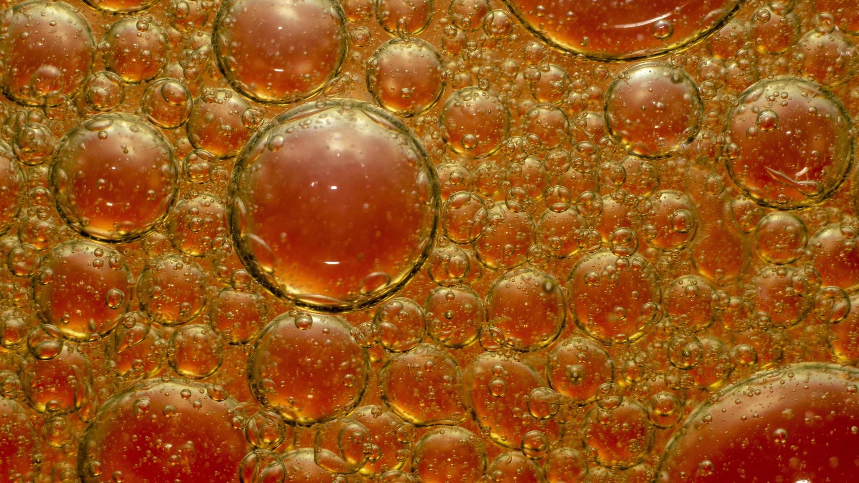 gotas de aceite aisladas en rojo foto