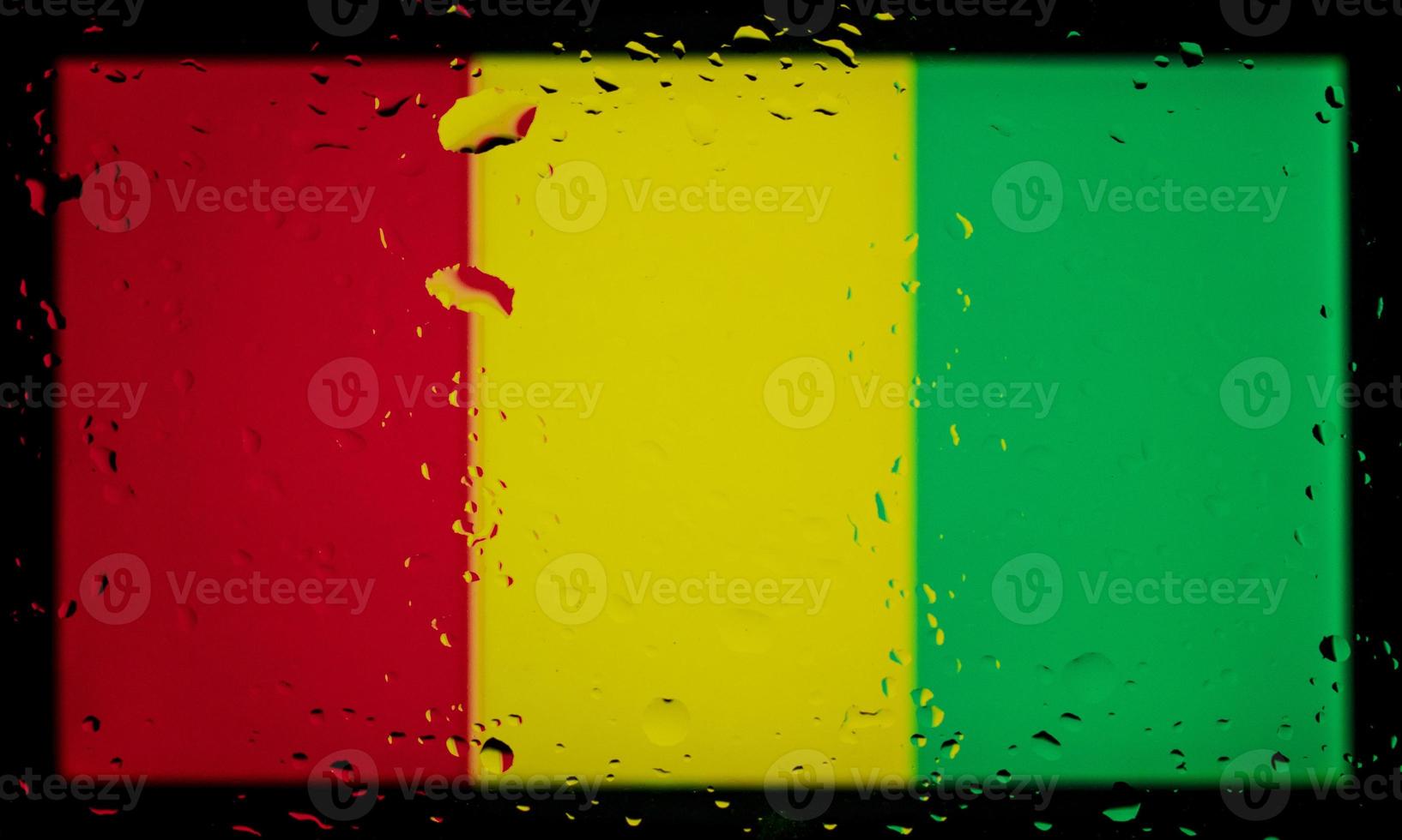 Drops of water on Guinea flag background. Shallow depth of field. Selective focus. Toned. photo