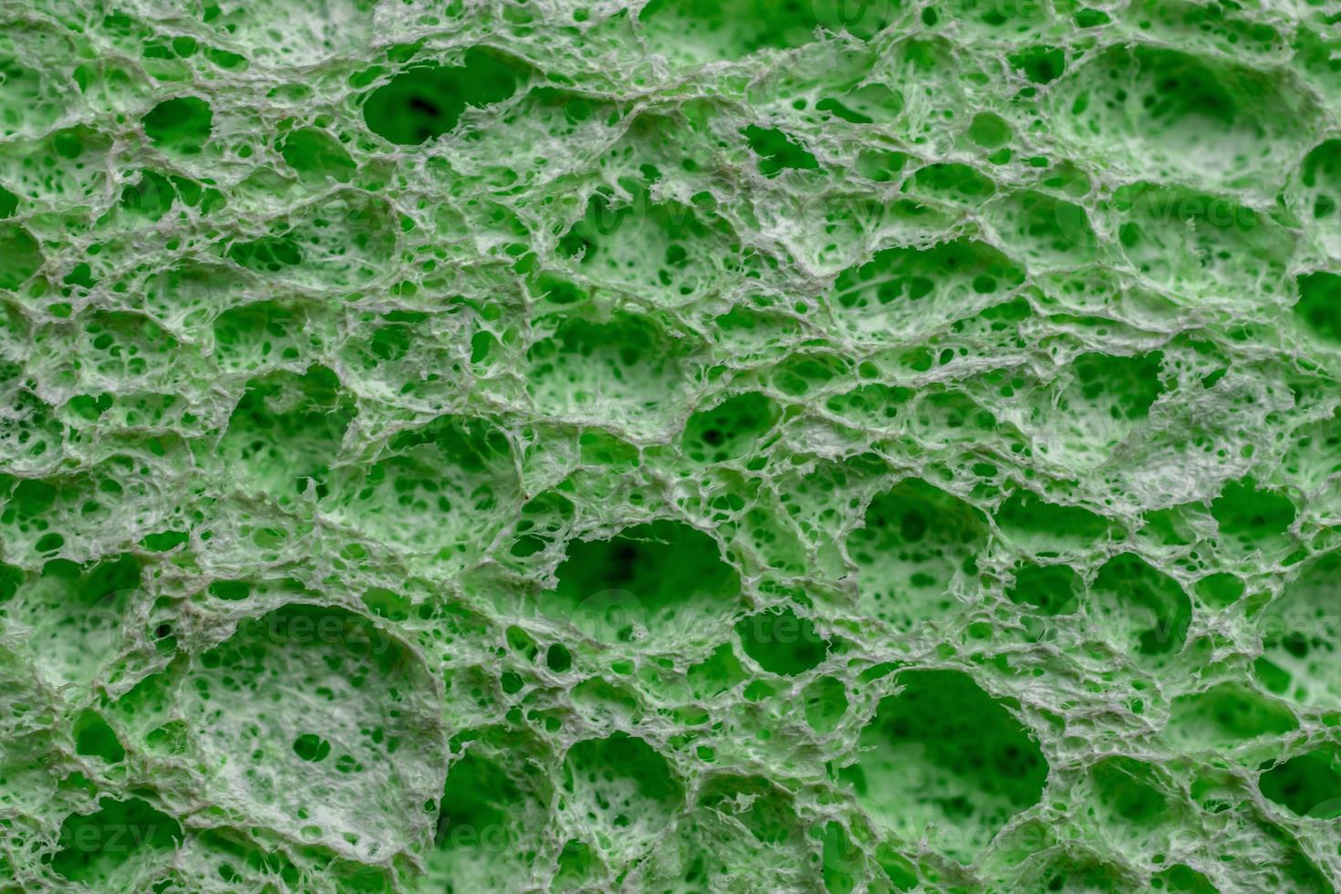 Sponge texture background. Green color cleaning sponge material detail close up view. Dish washing or beauty care. Macro photo