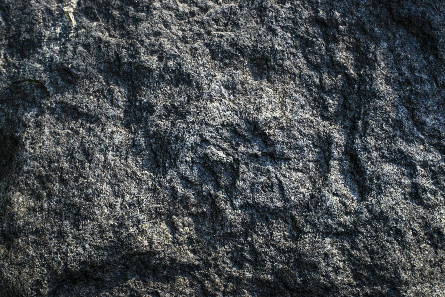 Raw gray granite rock texture background. Fragment of natural stone wall. Cracked, backdrop. photo