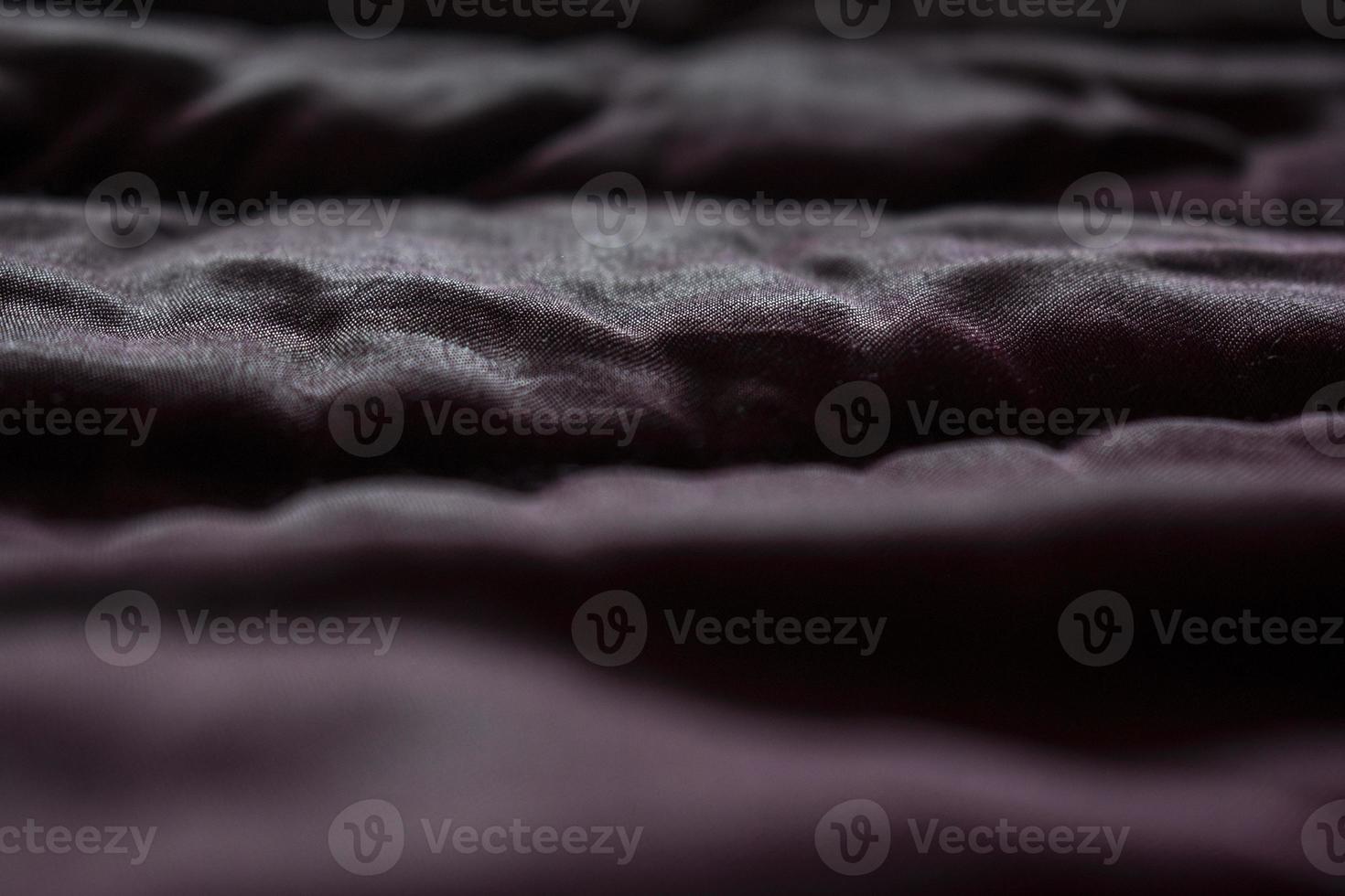 Shiny fabric texture with shadows. Abstract burgundy wallpaper. photo
