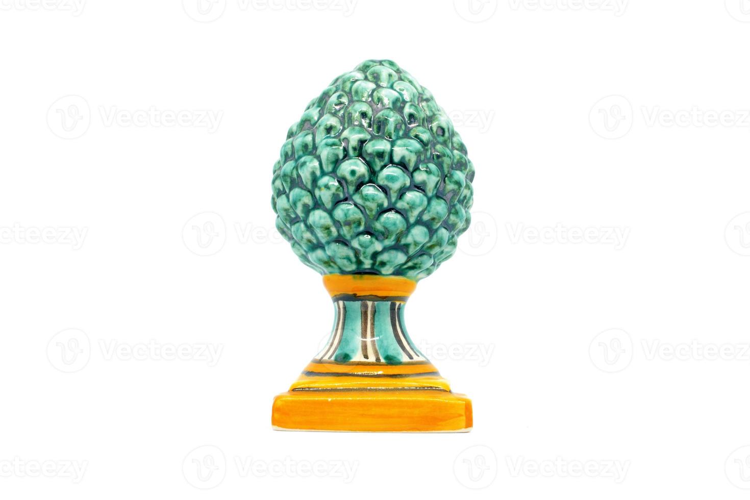 Green pine cone in Sicilian ceramic.Green pinecone in Sicilian ceramic from Caltagirone isolated on white background. photo