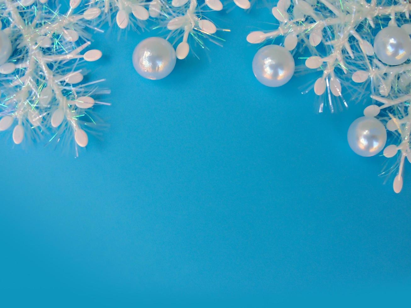 blue christmas background with white snowflakes and mother of pearl beads . copy space photo