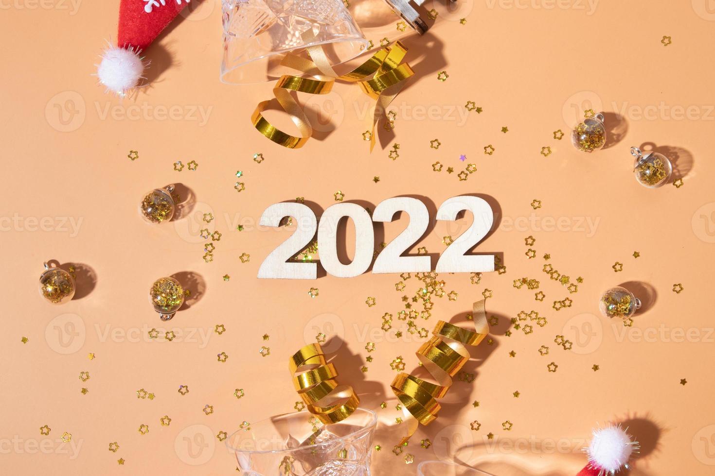 plano festivo de año nuevo con números 2022 y sombras duras con gafas y decoración brillante foto