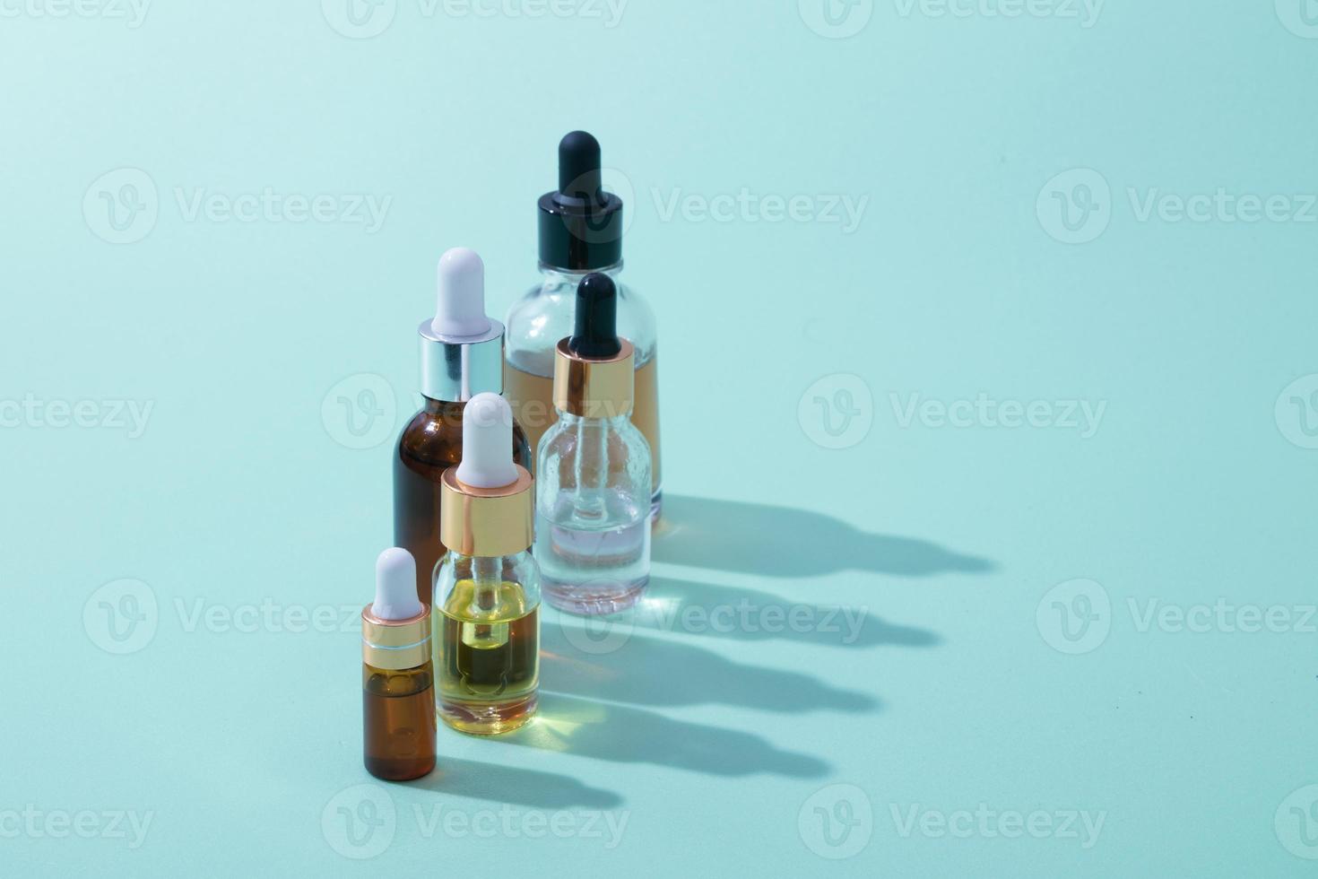 Cosmetic dropper bottles of oil and serum  with hard shadow photo