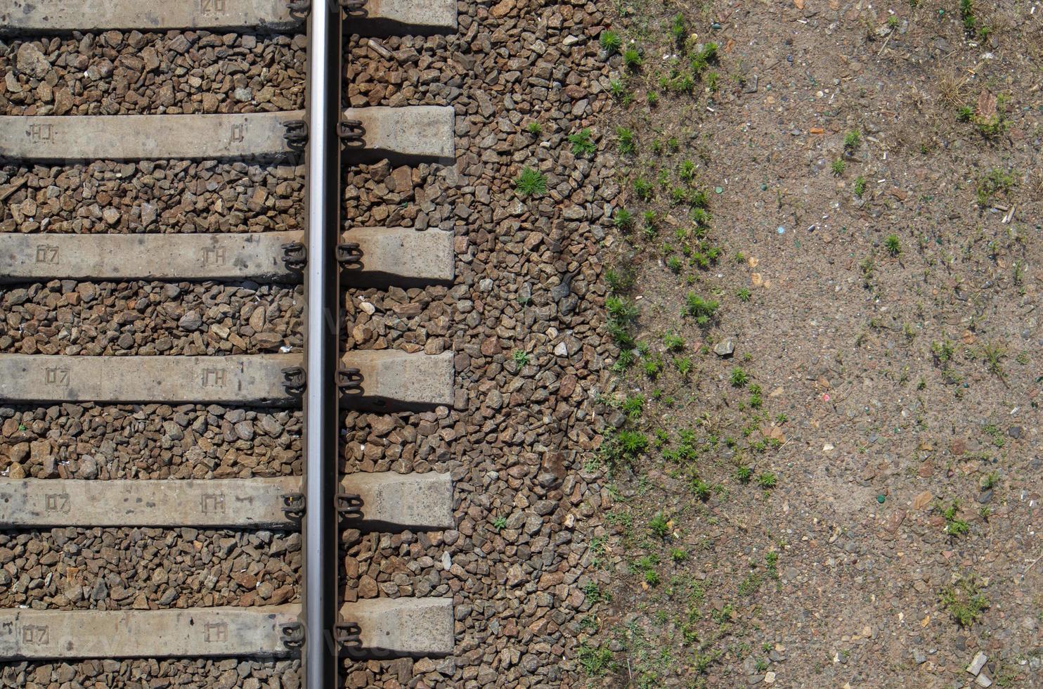 Railroad top view, flat lay. Part of the track for trains. Aerial view of a railway from a drone. Background with space for text. Shiny iron rails and concrete sleepers. photo