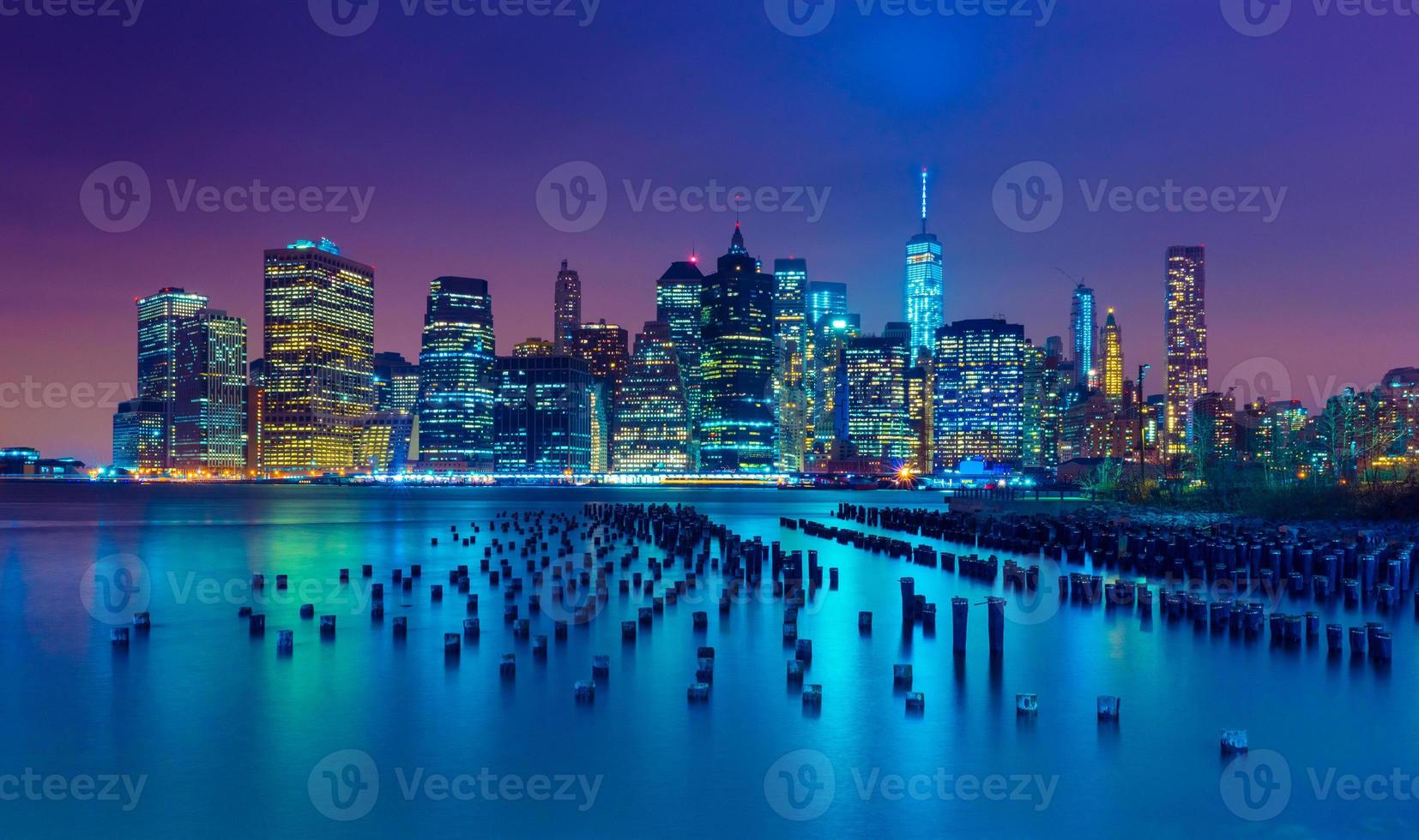 ciudad de nueva york por la noche. horizonte de manhattan. rascacielos reflejados en el agua. Nueva York, Estados Unidos foto