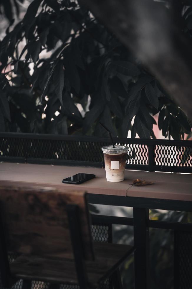 Iced latte and mobile phone on wood bar photo