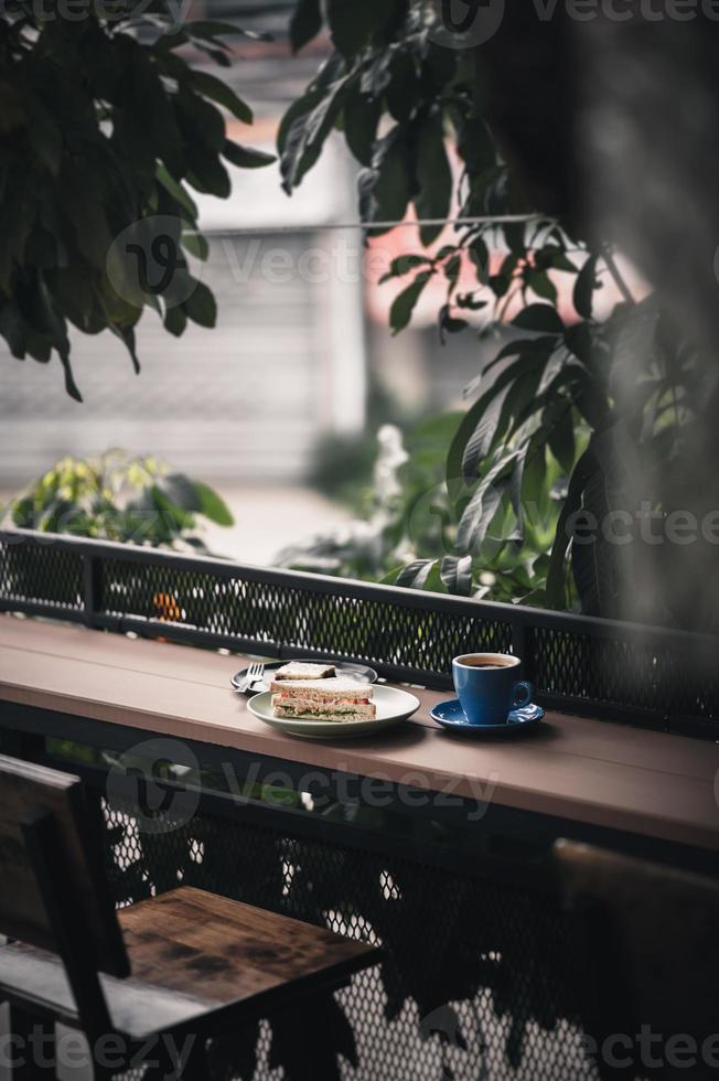 Sandwich and hot coffee on wood bar photo