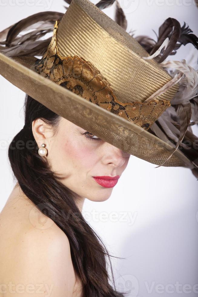 Beautiful woman with feather hat, and red lips. Retro fashion photo