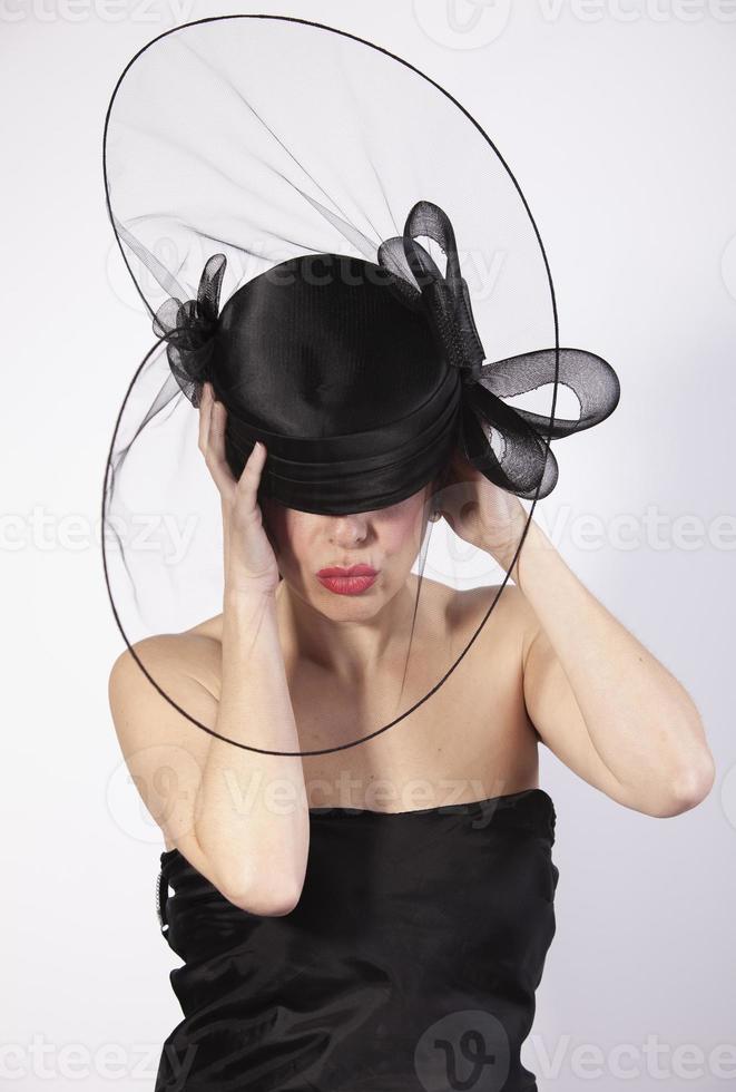 beautiful woman holding on black hat with hands, retro fashion photo