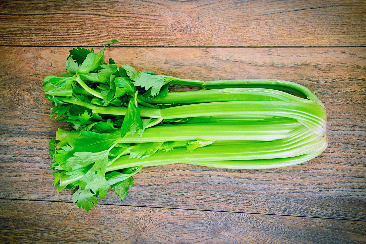 Fresh Juicy Celery on Woody Background photo