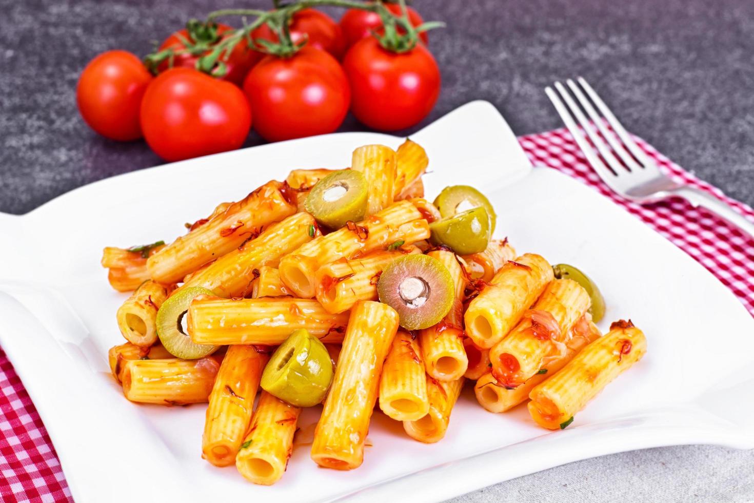 tortellini, pasna penne con salsa de tomate y aceitunas verdes foto