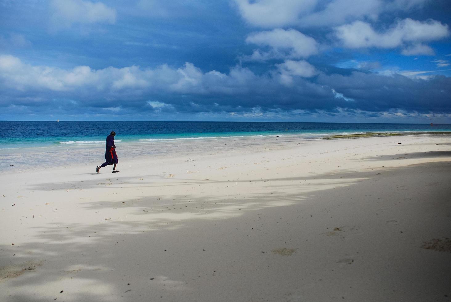 hombre caminando por la playa foto