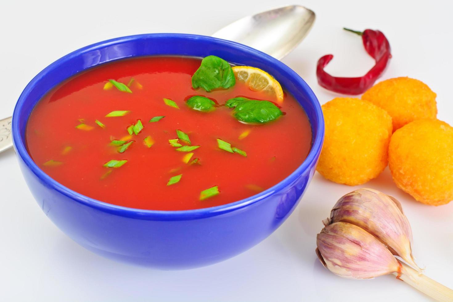 sopa de tomate con pimientos picantes, bolitas de queso, ajo y perejil foto