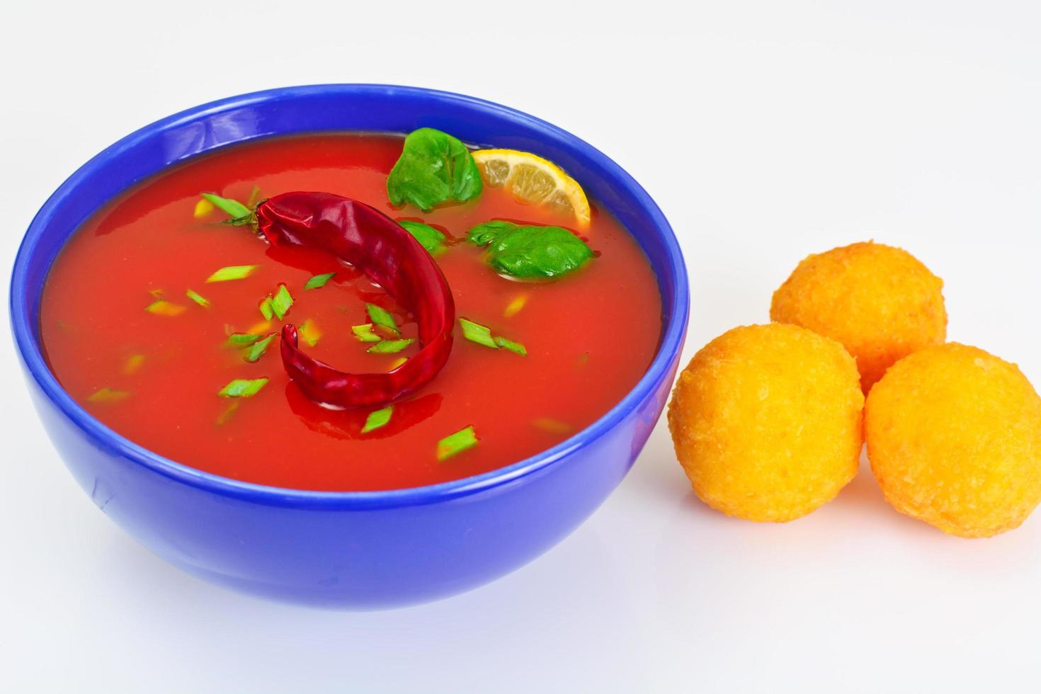 sopa de tomate con pimientos picantes, bolitas de queso, ajo y perejil foto