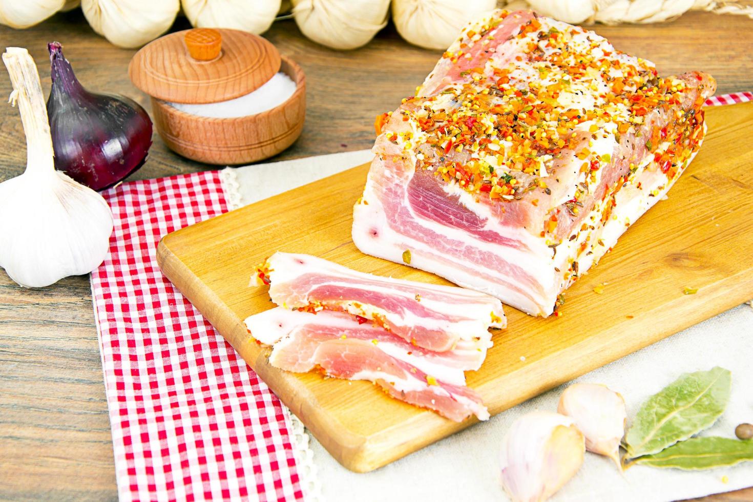 Manteca de cerdo salada, carne de cerdo cruda sobre tabla de cortar de madera foto