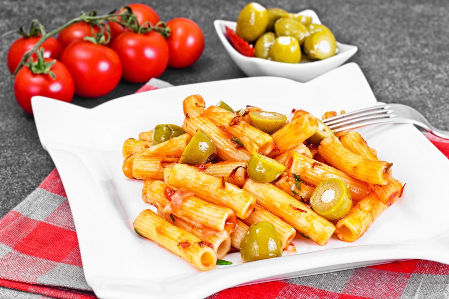 tortellini, pasna penne con salsa de tomate y aceitunas verdes foto