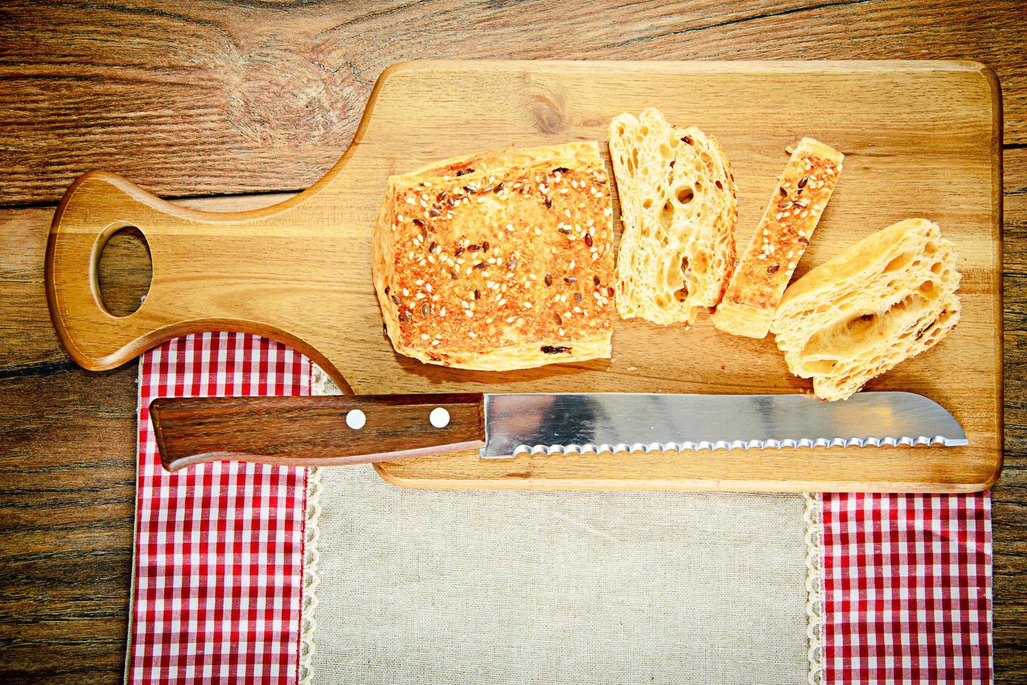 Rebanadas de pan con semillas de sésamo sobre una tabla de madera foto