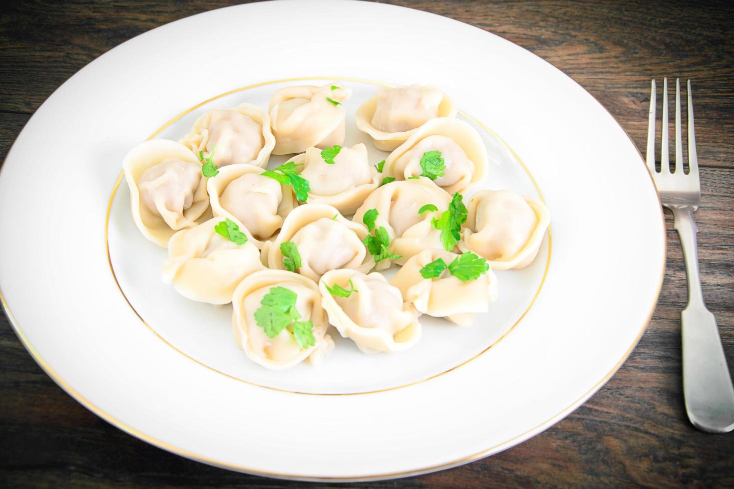 Tasty Homemade dumplings, Russian Pelmeni on Wood Background. photo