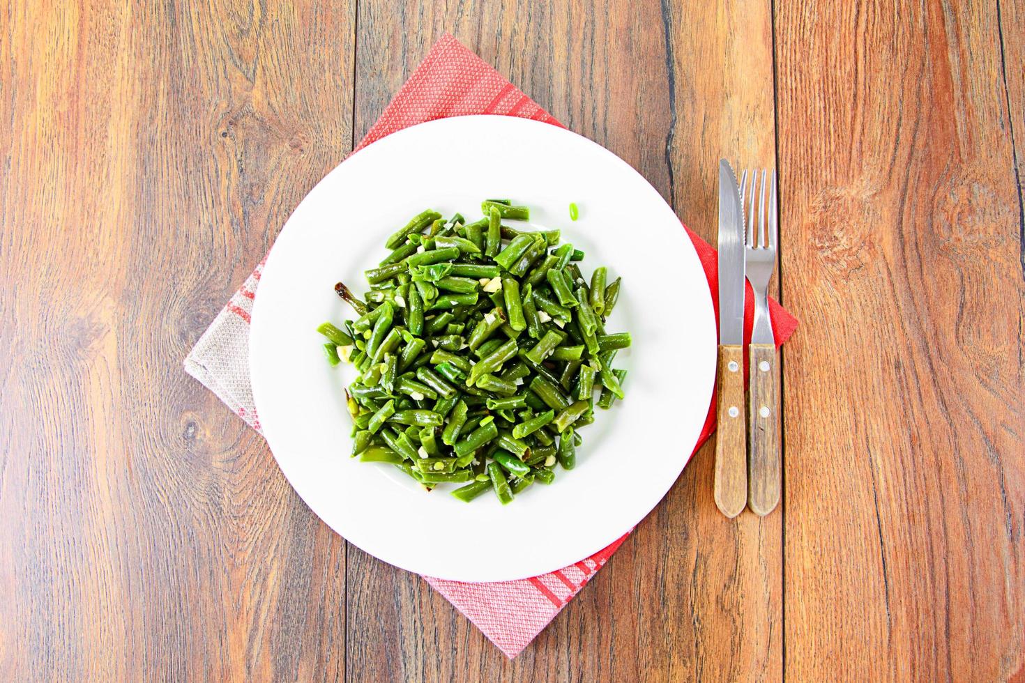 Green Beans Fried with Garlic on a White Plate. photo