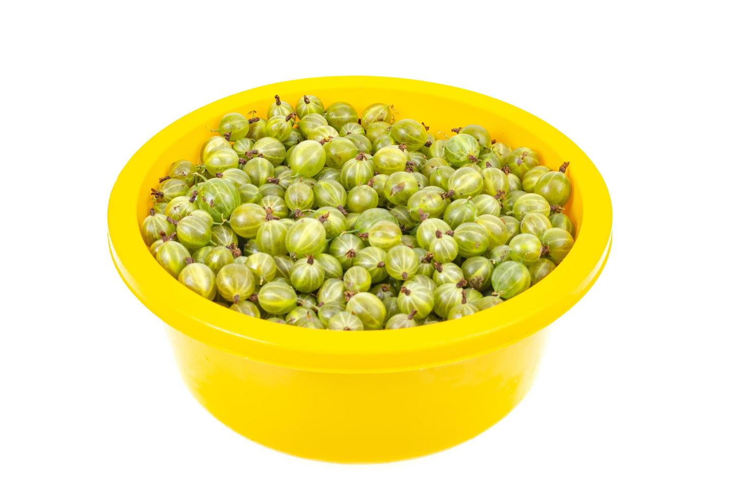 Ripe green gooseberries in yellow bowl. Photo