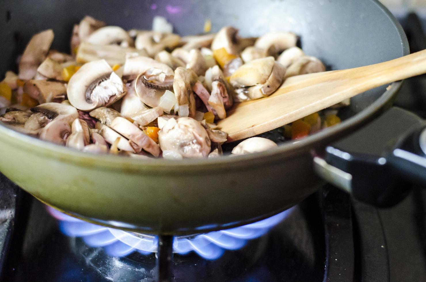 Champignons with onions are fried in pan, fire photo