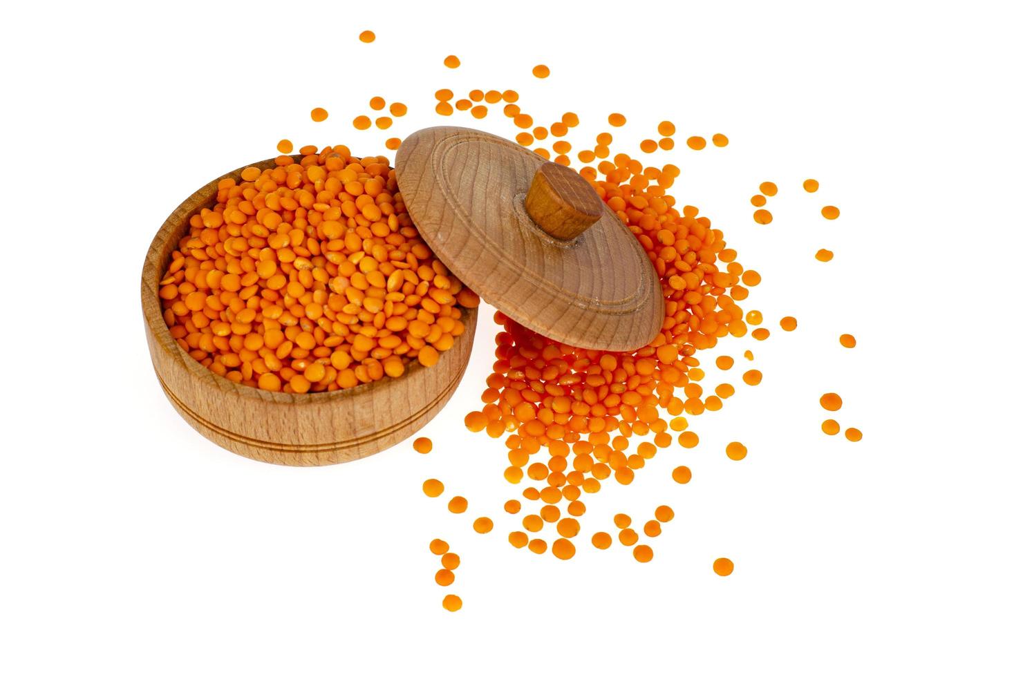 Red lentils in wooden jar on white background photo