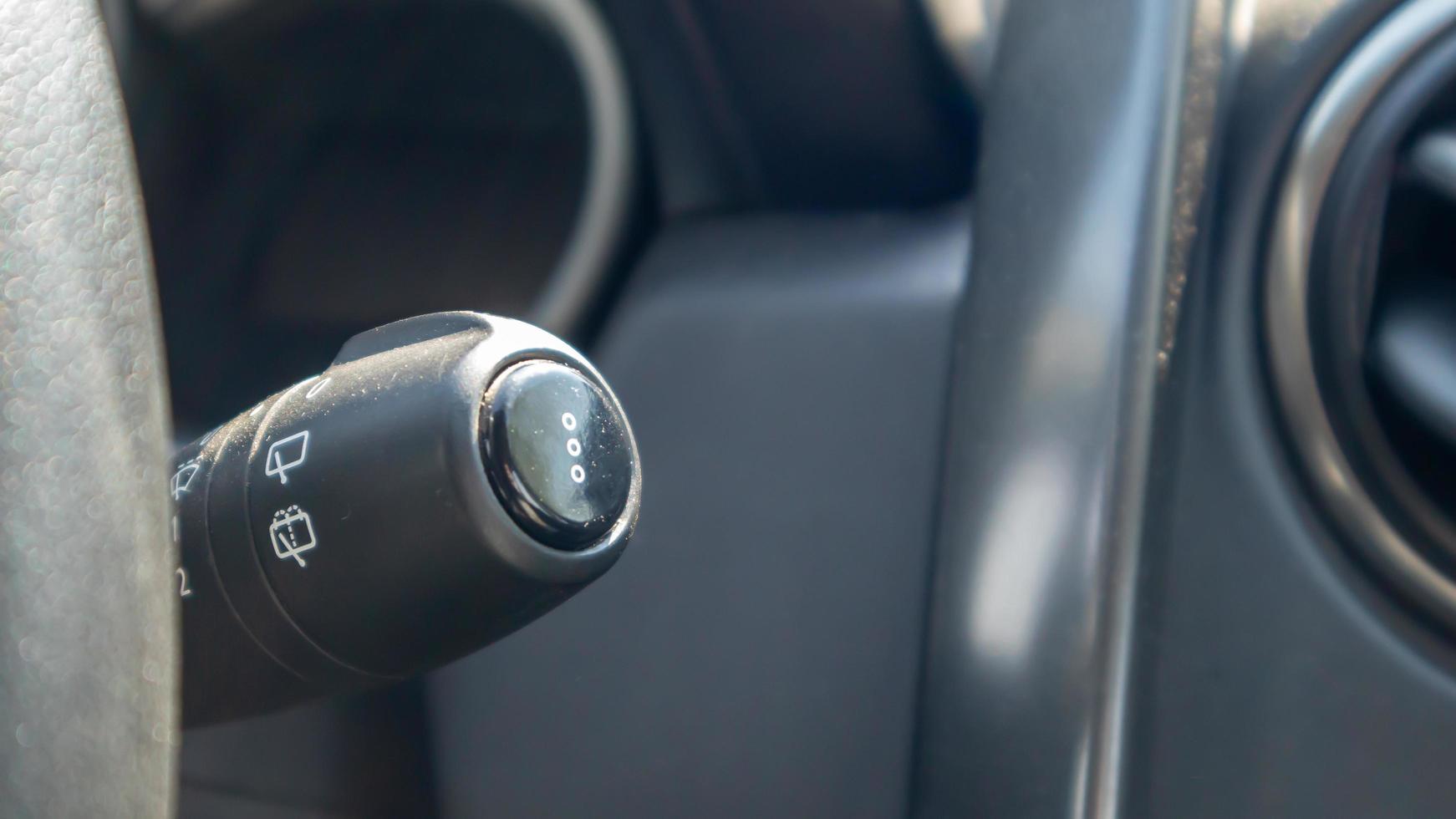 Handle for wipers control. Right wiper motor control switch. Detail of the car interior and adjustment of the speed of the wipers. Car windshield cleaner from rain. Remove dirt from the windshield. photo