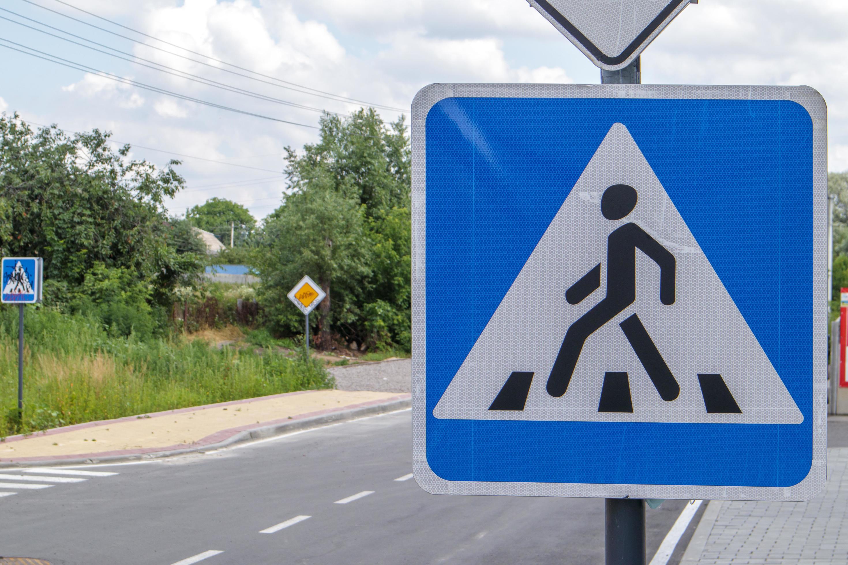 Pedestrian crossing road traffic sign showing a person on a zebra