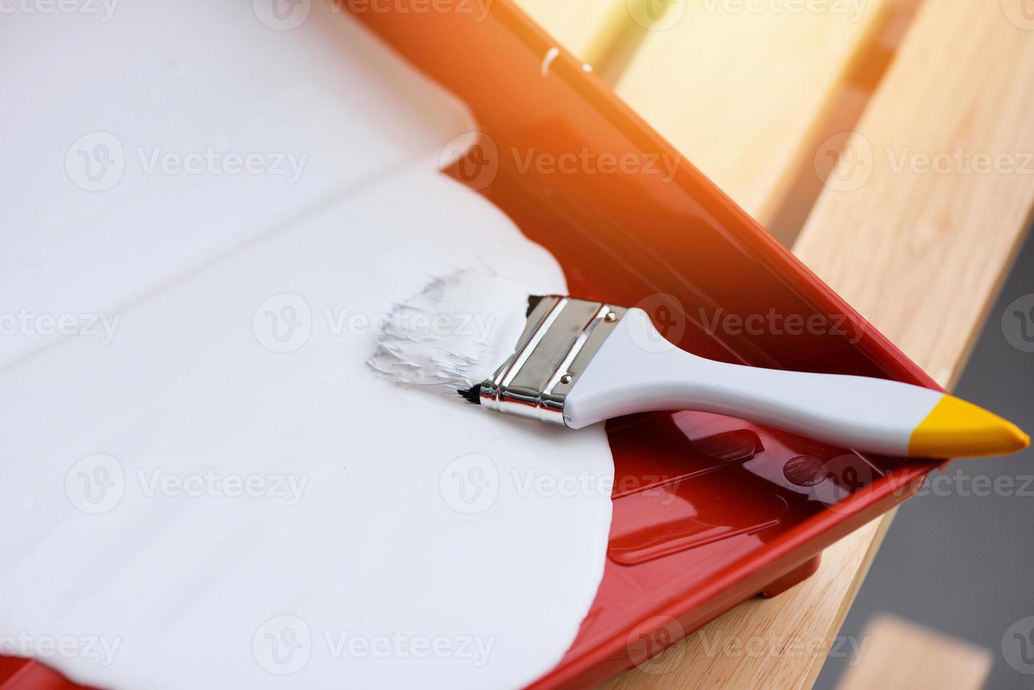 Painted tool with paint brush and paint roller on paint tray for painting photo