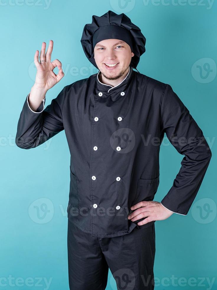 Male chef showing ok sign isolated on blue background photo