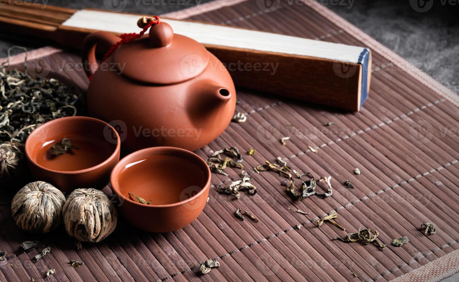 Asian teapot with cups and green tea on wooden placemat copy space photo