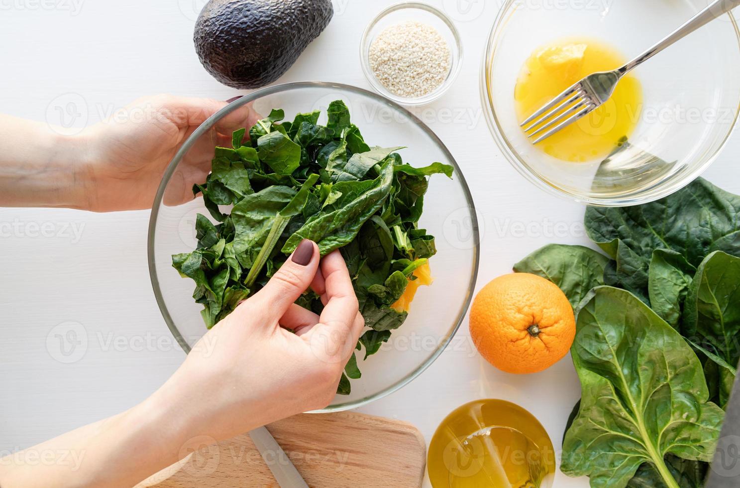 preparación paso a paso de ensalada de espinacas, aguacate y naranja. paso 6: juntar y mezclar todos los ingredientes foto