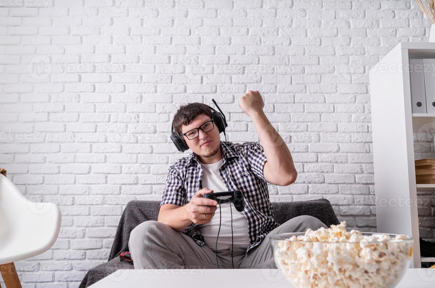 Excited young man playing video games at home enjoying his victory photo