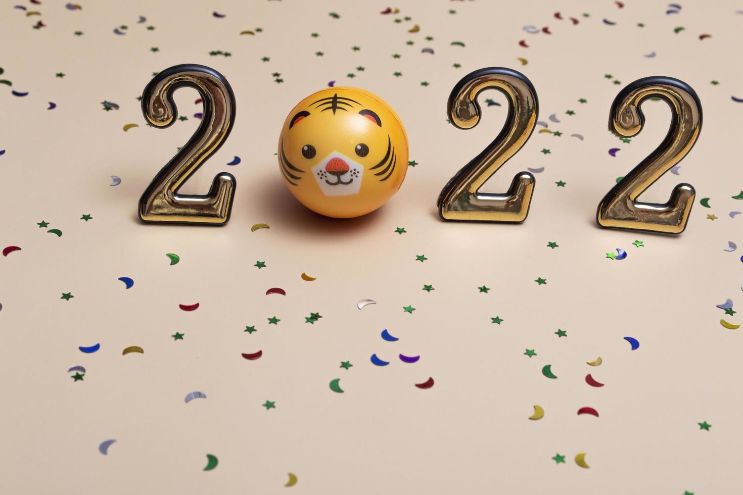 New year concept golden numbers 2022 with tiger face on beige background with copy space photo