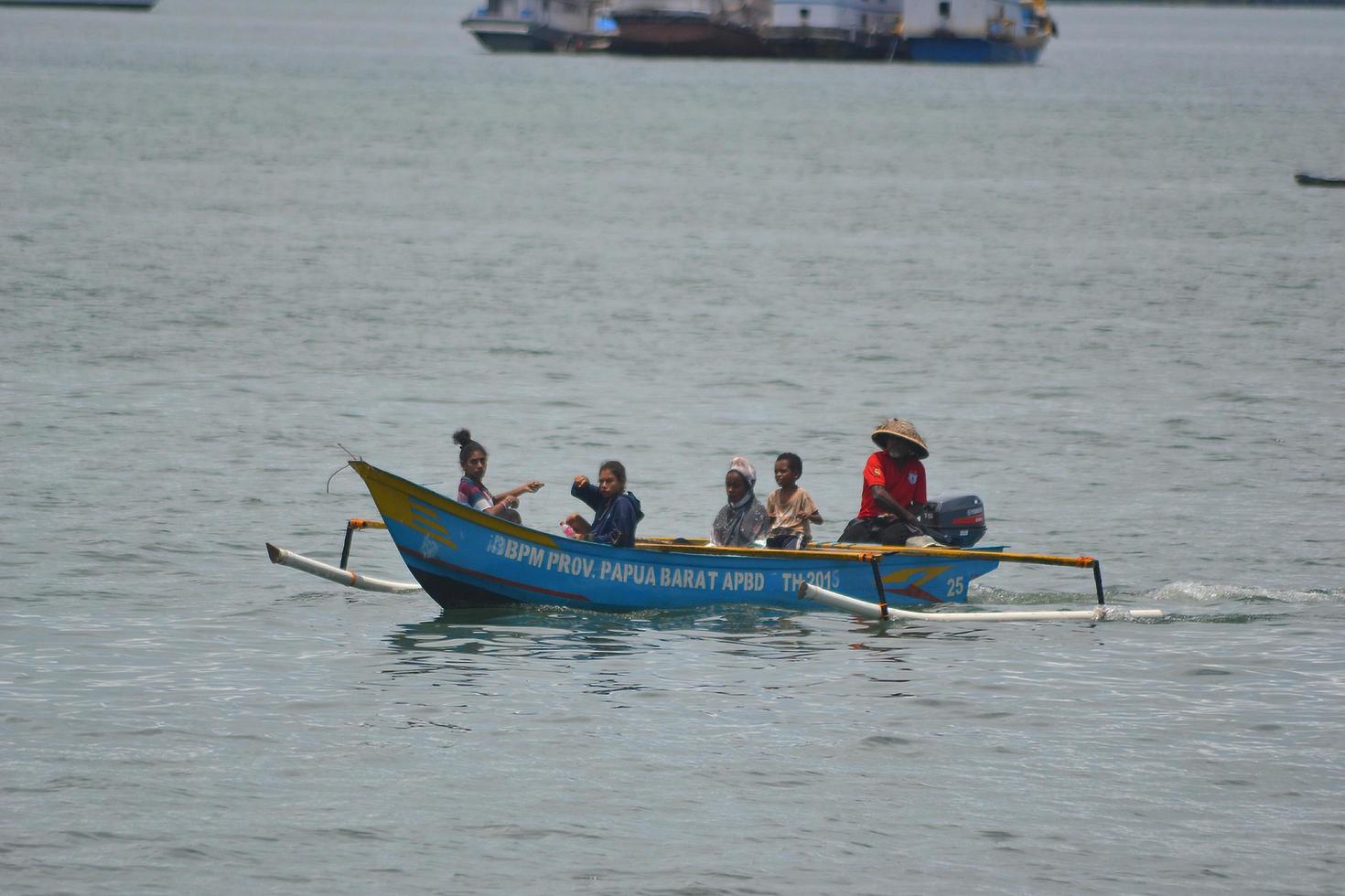 sorong, papua occidental, indonesia, 2021. aldeano cruzando el mar con barco de madera. foto