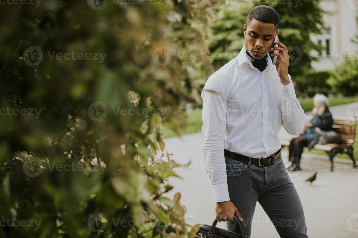 Young African American businessman using a mobile phone on a street photo