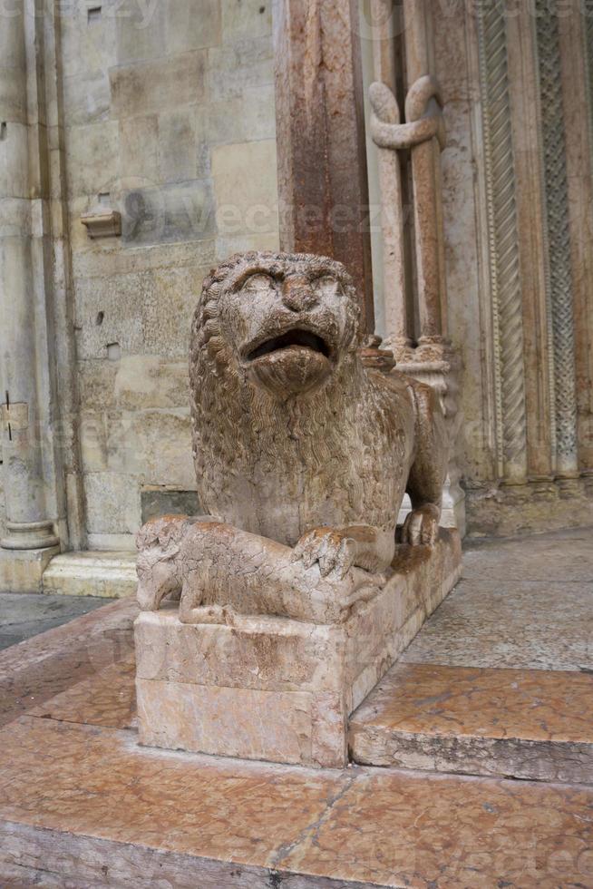 Sculpture of lion with pray in front of Duomo in Modena, Italy photo