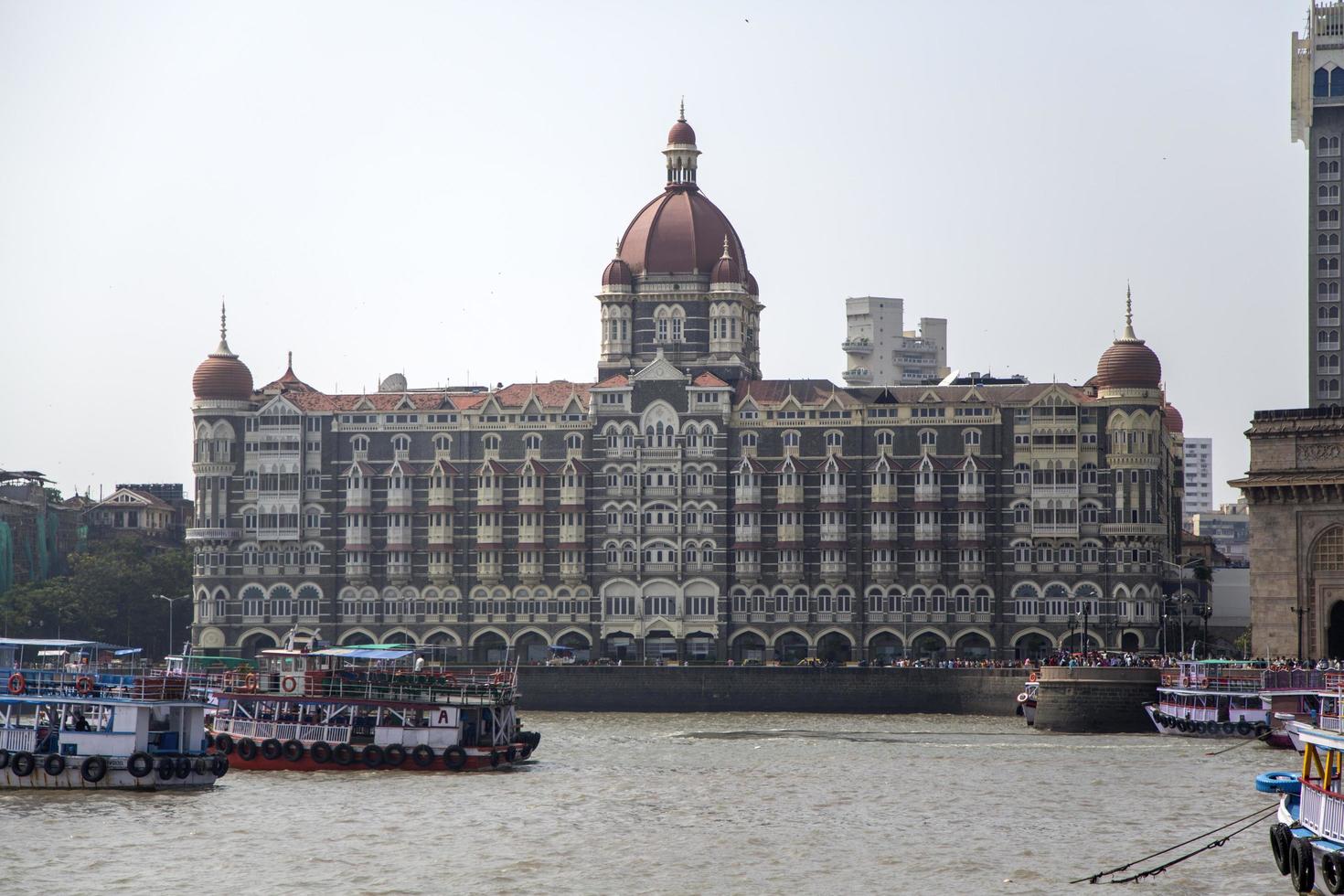 MUMBAI, INDIA, OCTOBER 11, 2015 - Boats in front of the Taj Mahal Palace Hotel. This 5 star hotel is considered the flagship property of the group and contains 560 rooms and 44 suites. photo