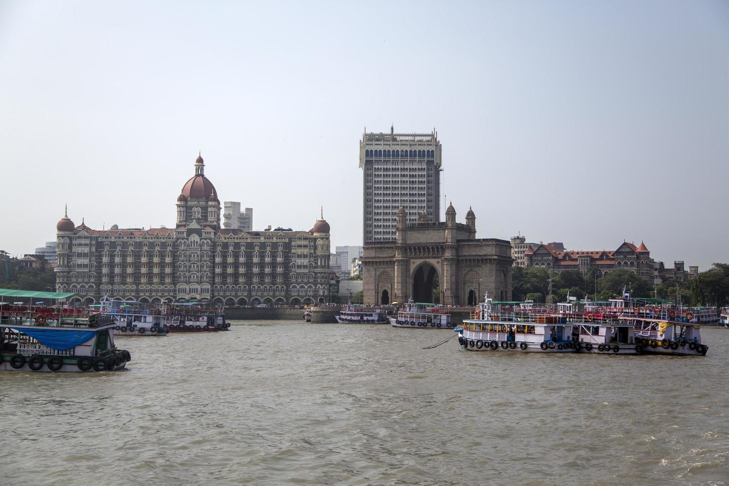 MUMBAI, INDIA, OCTOBER 11, 2015 - Boats in front of the Taj Mahal Palace Hotel. This 5 star hotel is considered the flagship property of the group and contains 560 rooms and 44 suites. photo